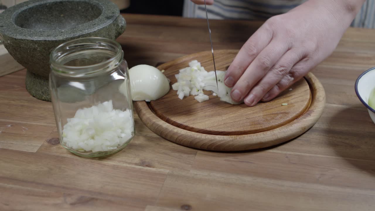 Hobby chef cuts onions into small dices for a dekucious chimichurri