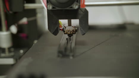 impresora 3d construyendo una pieza de plástico en cámara lenta