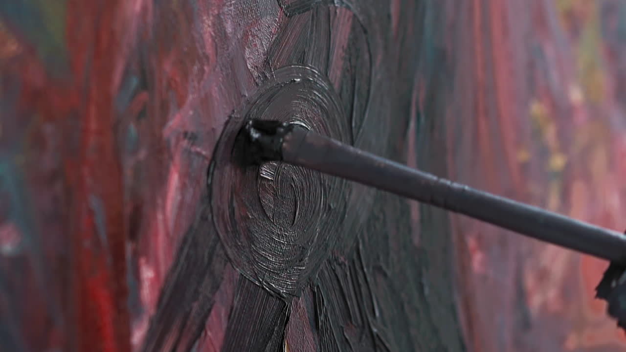 haciendo trazos circulares en el lienzo con pintura abstracta