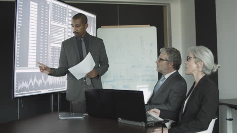 financial expert presenting stock market statistics on a meeting