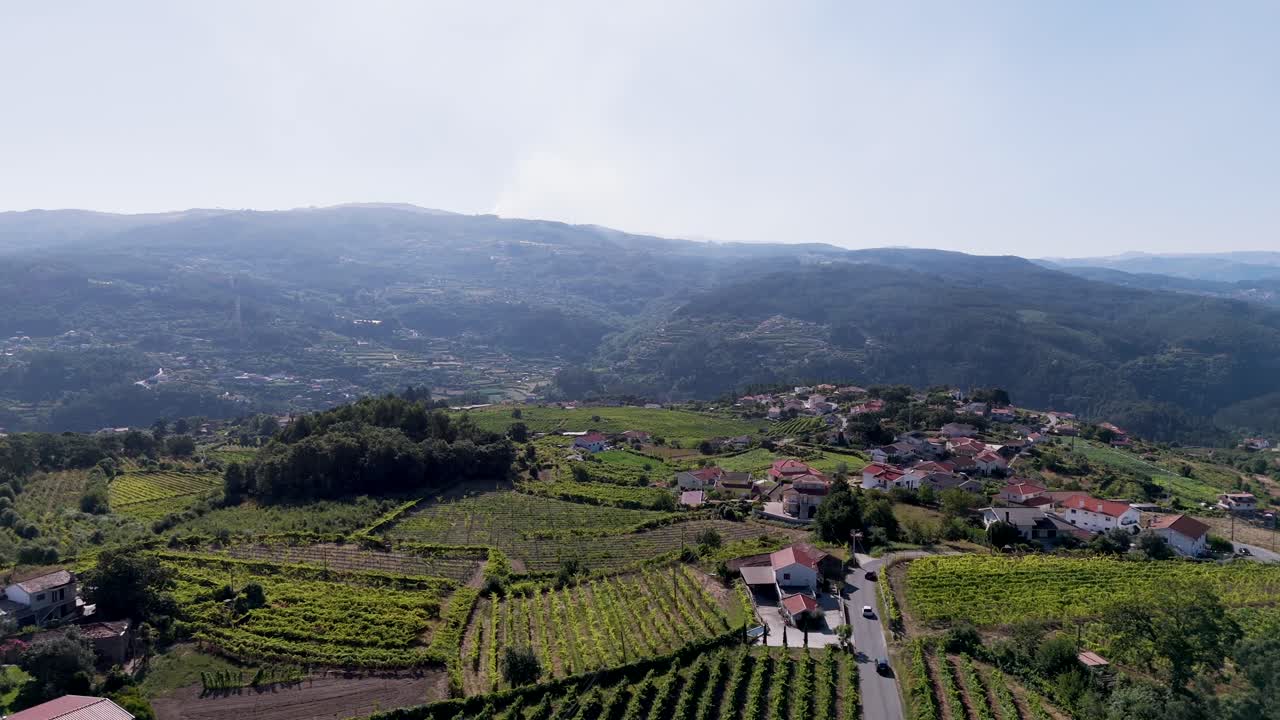 Vista aerea rotante di un drone su Castelo de Paiva con vigneti, case e montagne in Portogallo