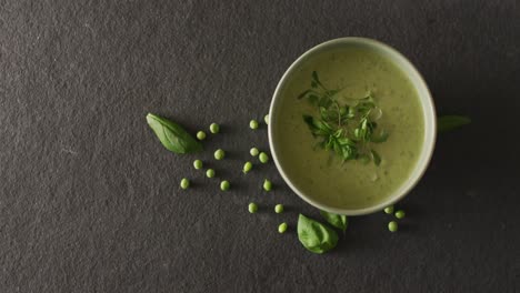 video de sopa de guisantes verdes en un plato en la mesa gris