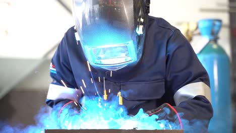 a slow motion gimbal shoot of a man welding metal together