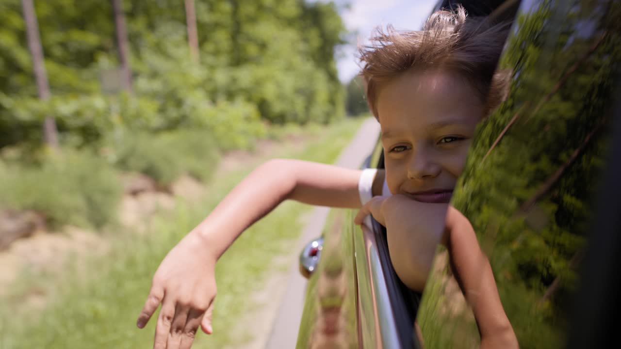 Handheld video of boy with hands on the road breeze