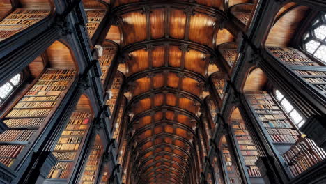 grand library interior with ornate vaulted wooden ceiling and bookshelves