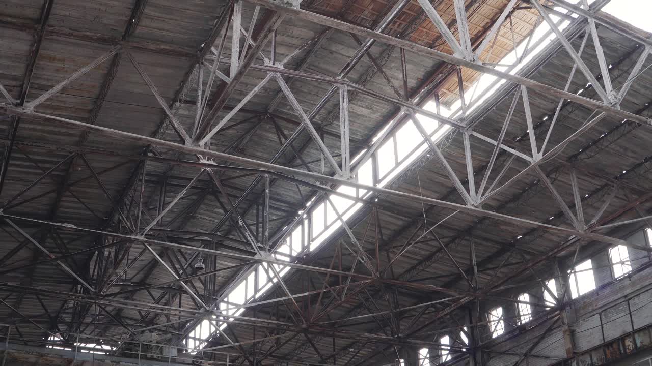 Old rusty metal roof structure in an abandoned factory. Factory ruins