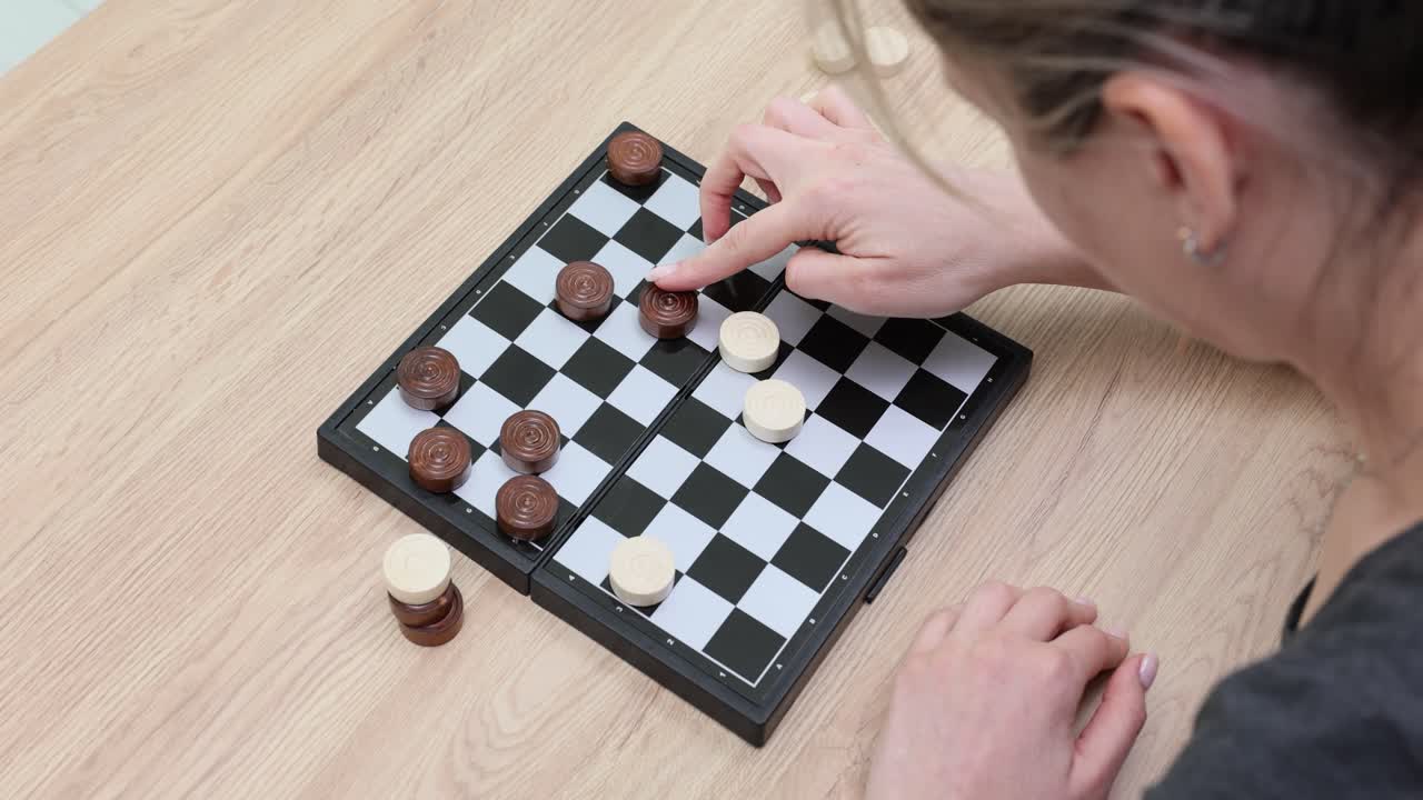 A woman plays checkers