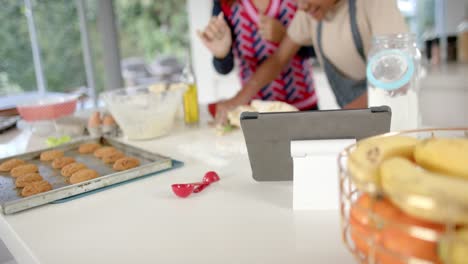 Happy-african-american-mother-and-son-baking-in-kitchen,-slow-motion