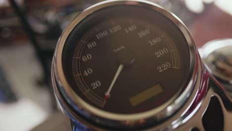 handheld black speedometer of a modern vintage style motorcycle, shallow focus