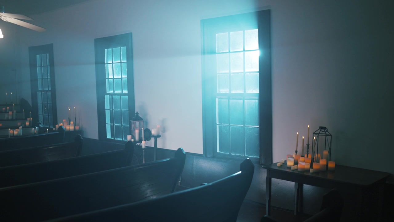 Intérieur d'église vide avec des bougies et des rayons de lumière des fenêtres
