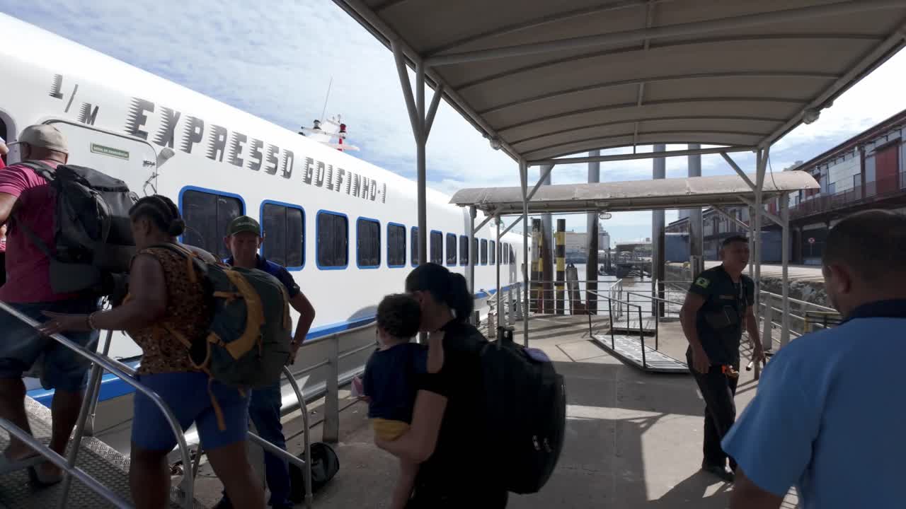 Passengers and crew boarding an express boat at a port