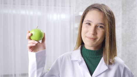 Positive-dietitian-woman-recommends-healthy-eating,-shows-fresh-apples.