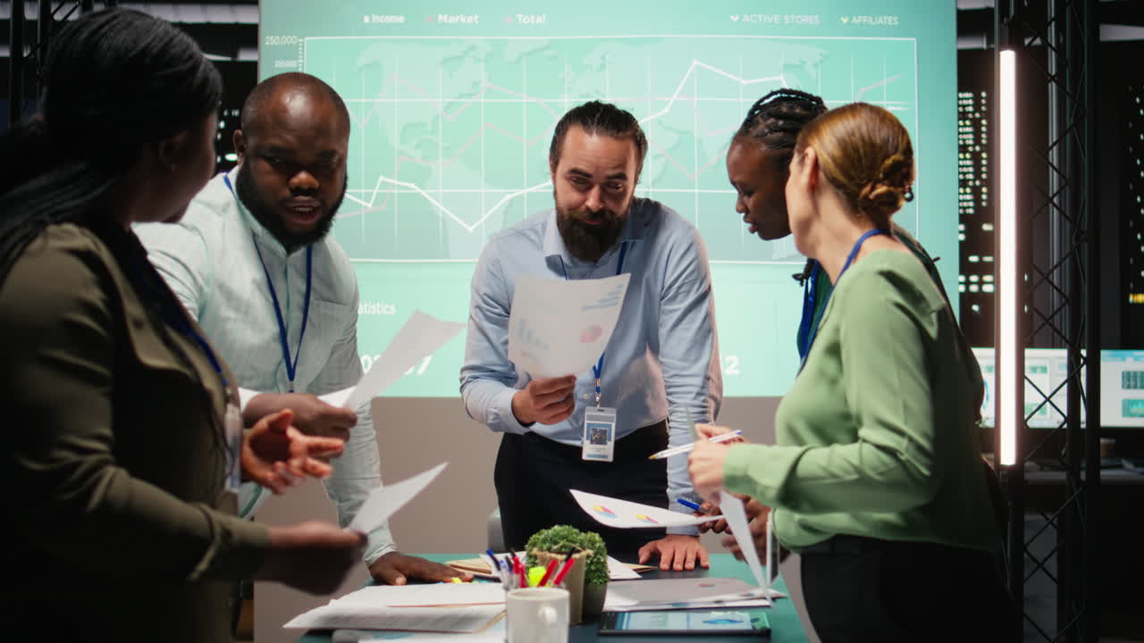 Diverse group of professionals review files and performance metrics