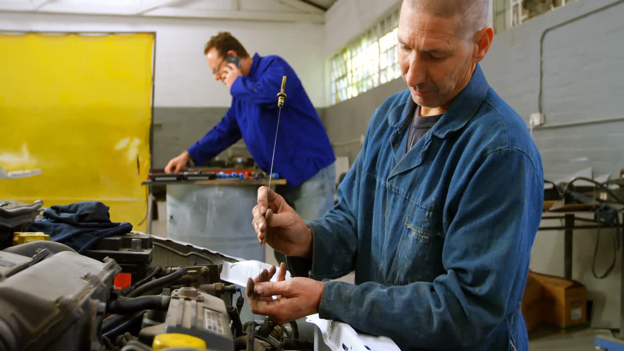 mecánico examinando un coche 4k