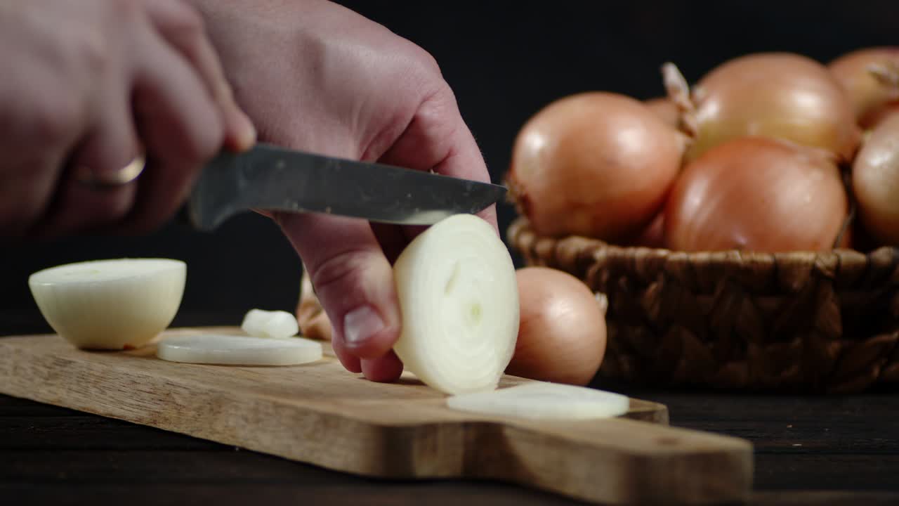 Men hands cut onions into round slices.