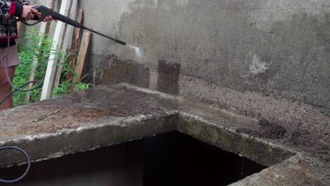 un hombre está empleando una manguera de presión para lavar el exterior de un invernadero - lapso de tiempo