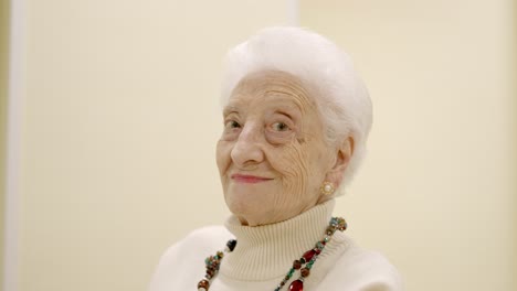 old woman smiling looking at the camera sitting on geriatric