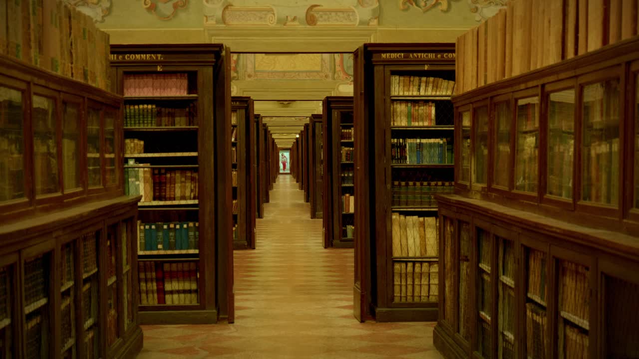 Long library corridor with tall bookshelves inside historic Bologna building