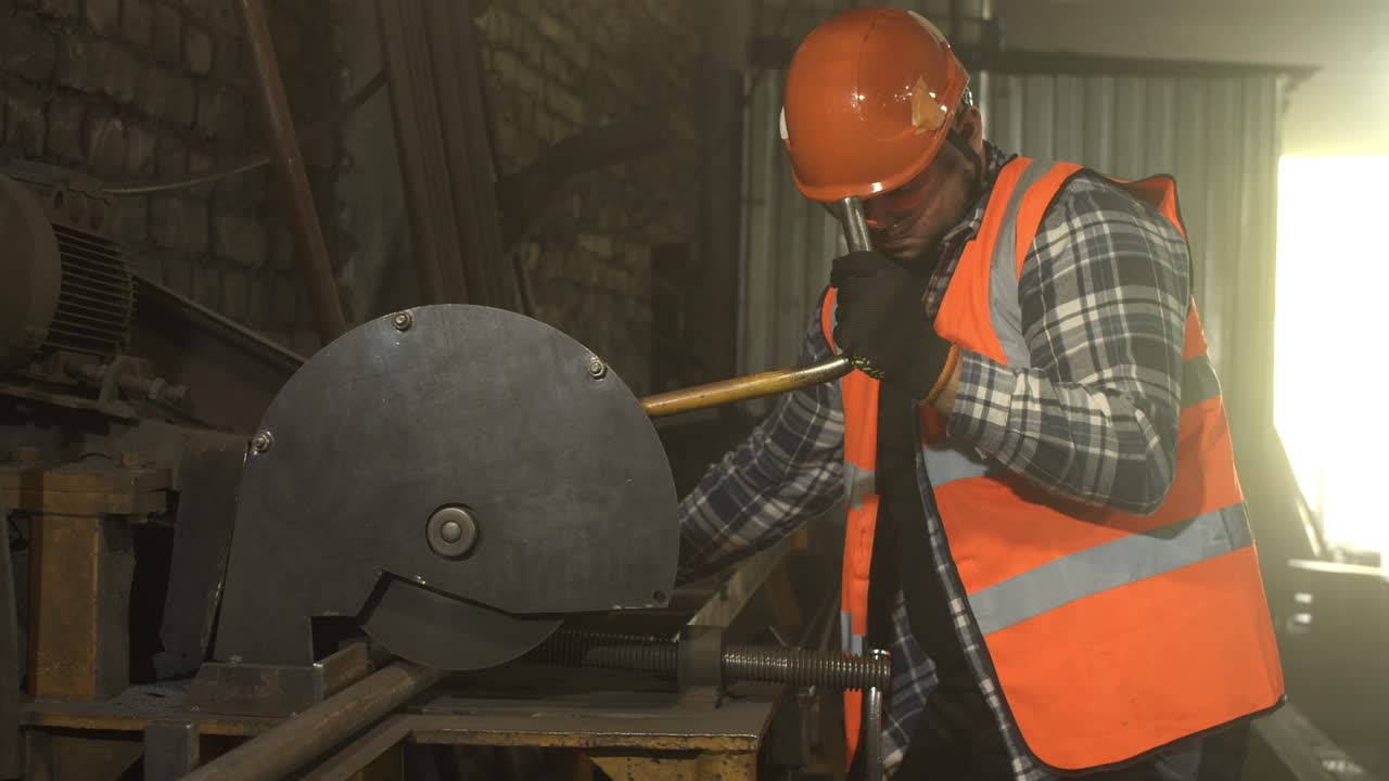 Male worker cutting metal in grungy workshop