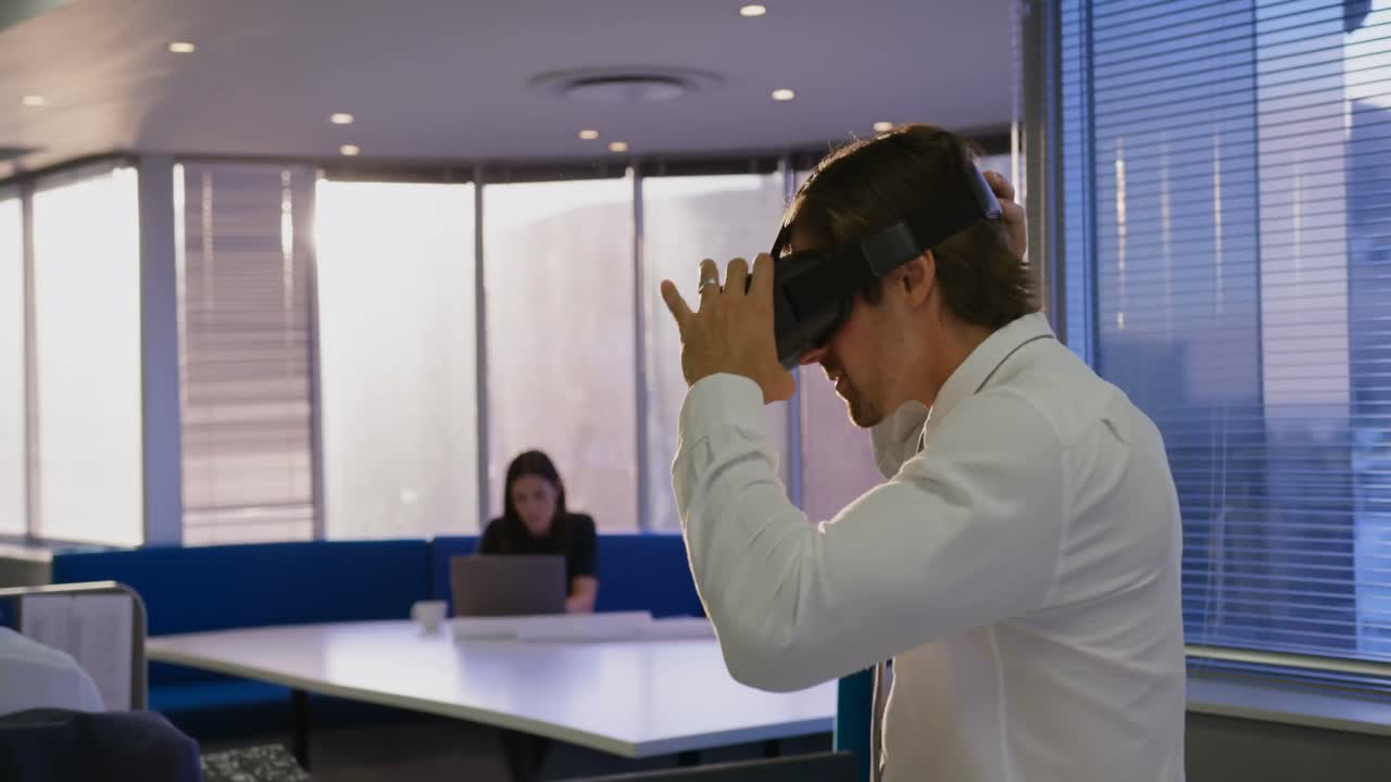 vista lateral de un joven ejecutivo caucásico que usa auriculares de realidad virtual en una oficina moderna 4k