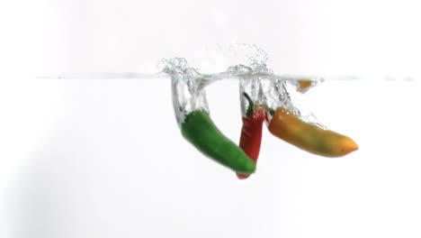 chilies falling into water in super slow motion