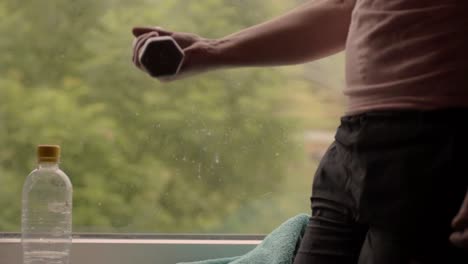 Woman-lifting-hand-weight-dumbbells-in-front-of-window