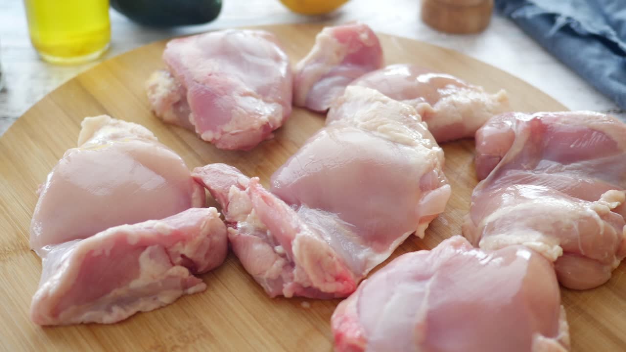 muslos de pollo crudos en una tabla de cortar