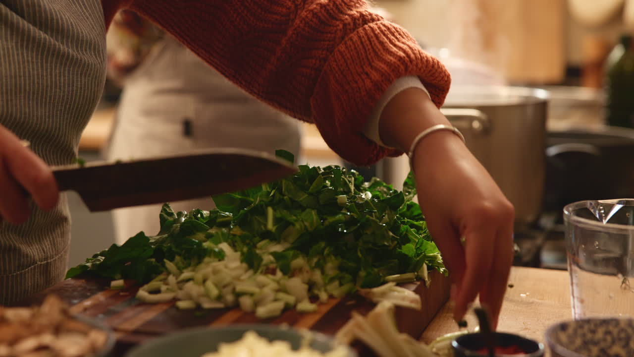un primer plano de un chef cortando verduras en una cocina
