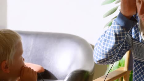 father and children listening to music on headphones at home 4k