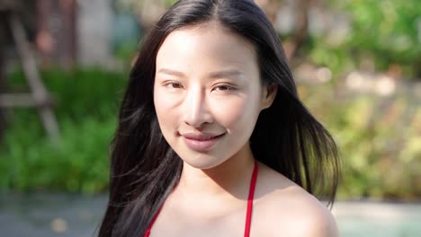 asian woman in red bikini by pool