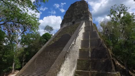 A-towering-ancient-structure-surrounded-by-the-lush-Guatemalan-jungle,-captured-from-the-skies