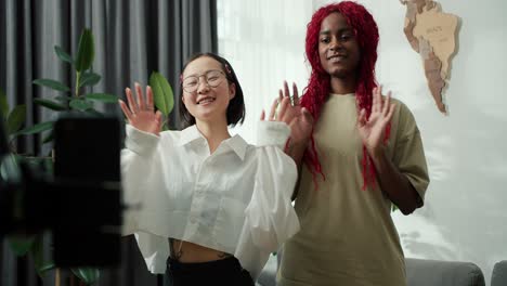 dos chicas afroamericanas y asiáticas grabando movimientos de baile de moda para la cuenta de redes sociales