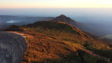 Erstaunliche-Luftaufnahme-Einer-Wunderschönen-Bergkette,-Die-Bei-Sonnenaufgang-Von-Wolken-Umgeben-Ist