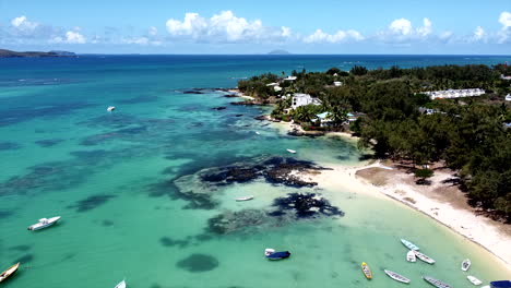 Slow-aerial-birds-eye-shot-of-sandy-beach,villas-and-boats-on-turquoise-sea