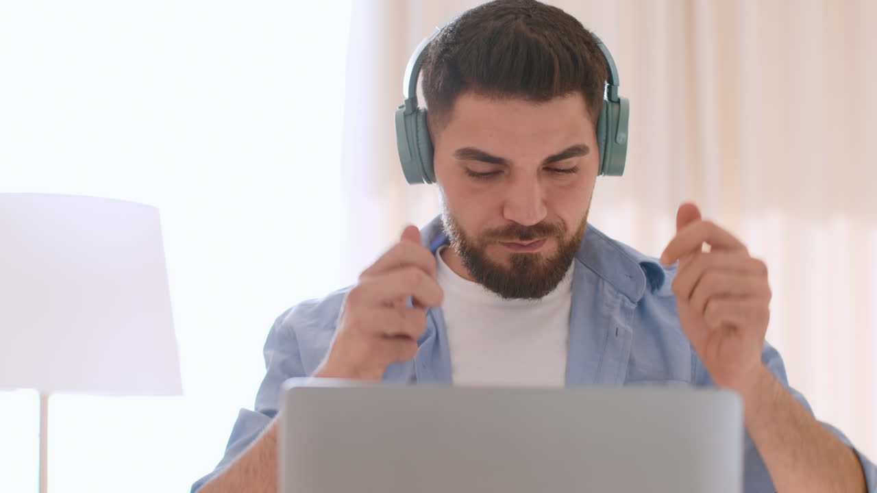 Man working from home on laptop with headphones