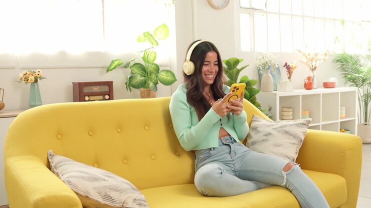 Woman listening to music on headphones at home
