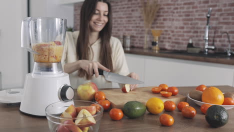 giovane femmina che prepara il succo di frutta con il frullatore