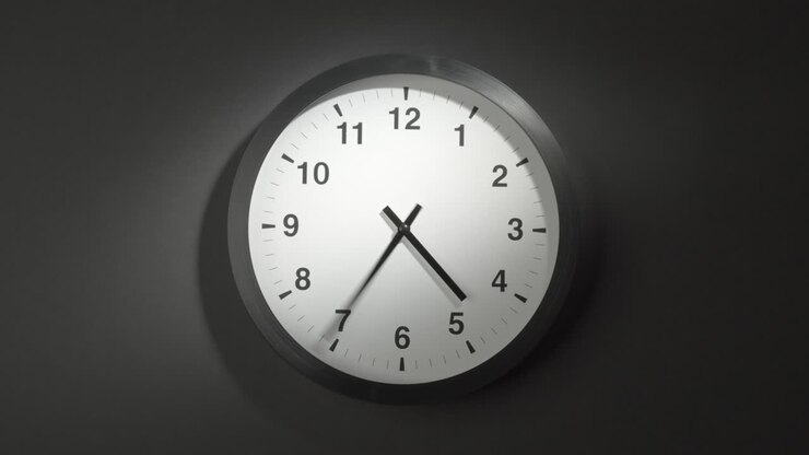 Clock Face in Time Lapse on Dark Grey Wall