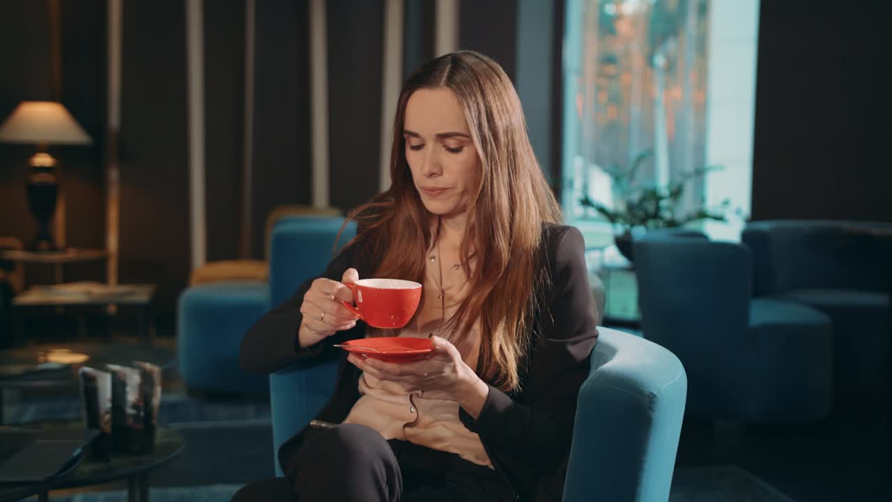 Forretningskvinde drikker te i hotellobbyen. Forretningskvinde drikker kaffe.