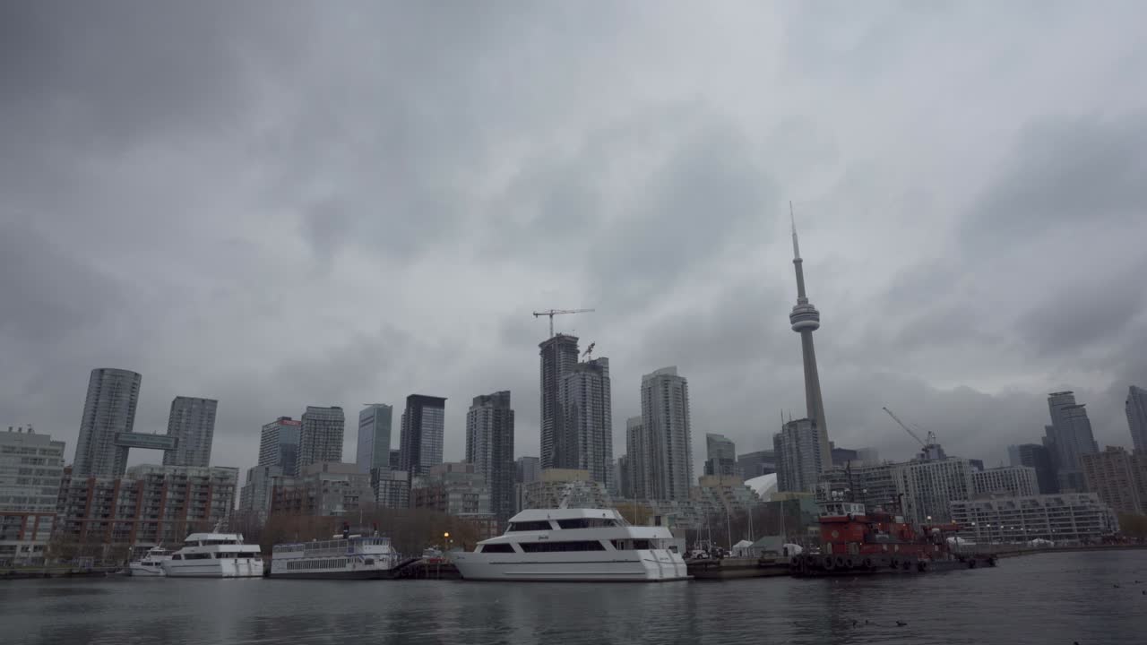 Inquadratura fissa di barche ormeggiate nel Toronto Harbourfront con lo skyline sullo sfondo in una giornata nuvolosa