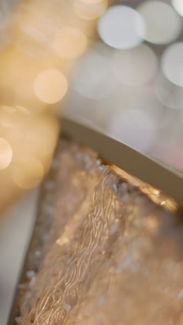 close-up of intricate gold frame illuminated by warm glowing light, featuring detailed patterns and surrounded by blurred bokeh effects