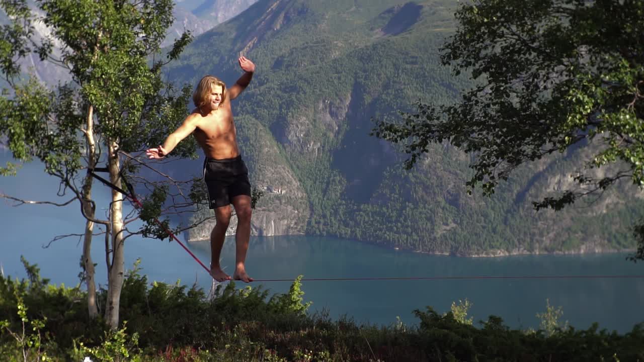 hombre caminando en un slackline en un hermoso paisaje natural, noruega, europa