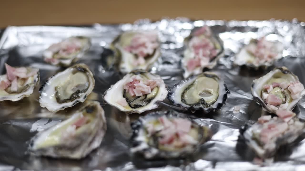 손은 트레이에 있는 신선한 오스트리에 토핑을 첨가합니다.