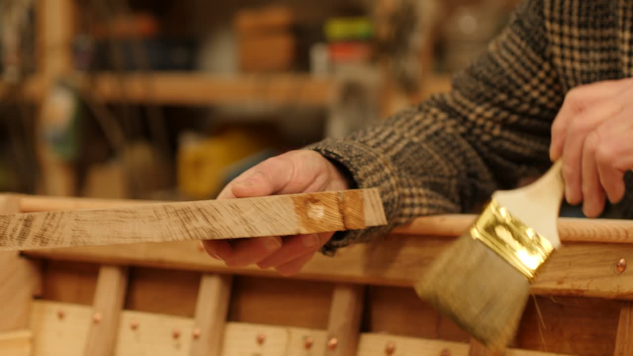 Shipwright Applying Oil to Wooden Boat seat knee