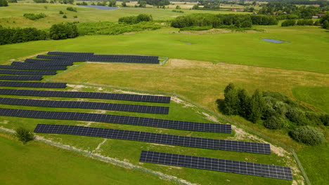 Toma-Cinematográfica-Hacia-Atrás-Del-Campo-Agrícola-De-Paneles-Solares-De-Energía-Renovable-Verde---Polonia,-Zielenica