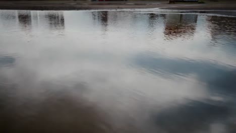 puddle reflection of clouds and buildings