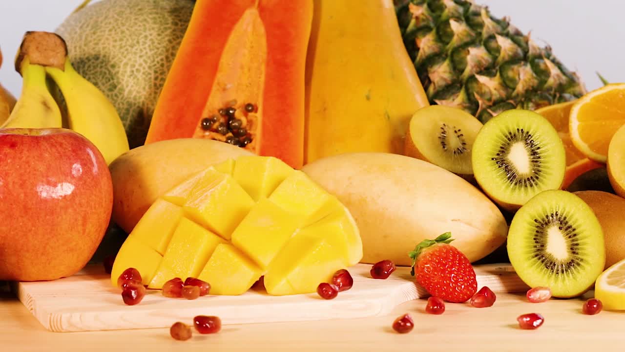 Una carrellata lenta attraverso una varietà colorata di frutta fresca, affettata e intera.