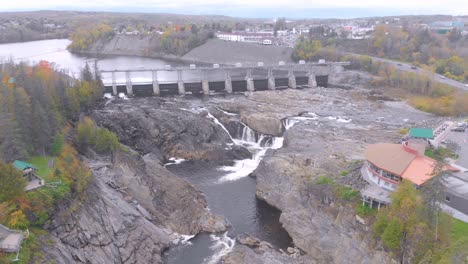 high flying aerial shot of the grand falls located in new brunswick on a sunny day as the camera descends towards the river