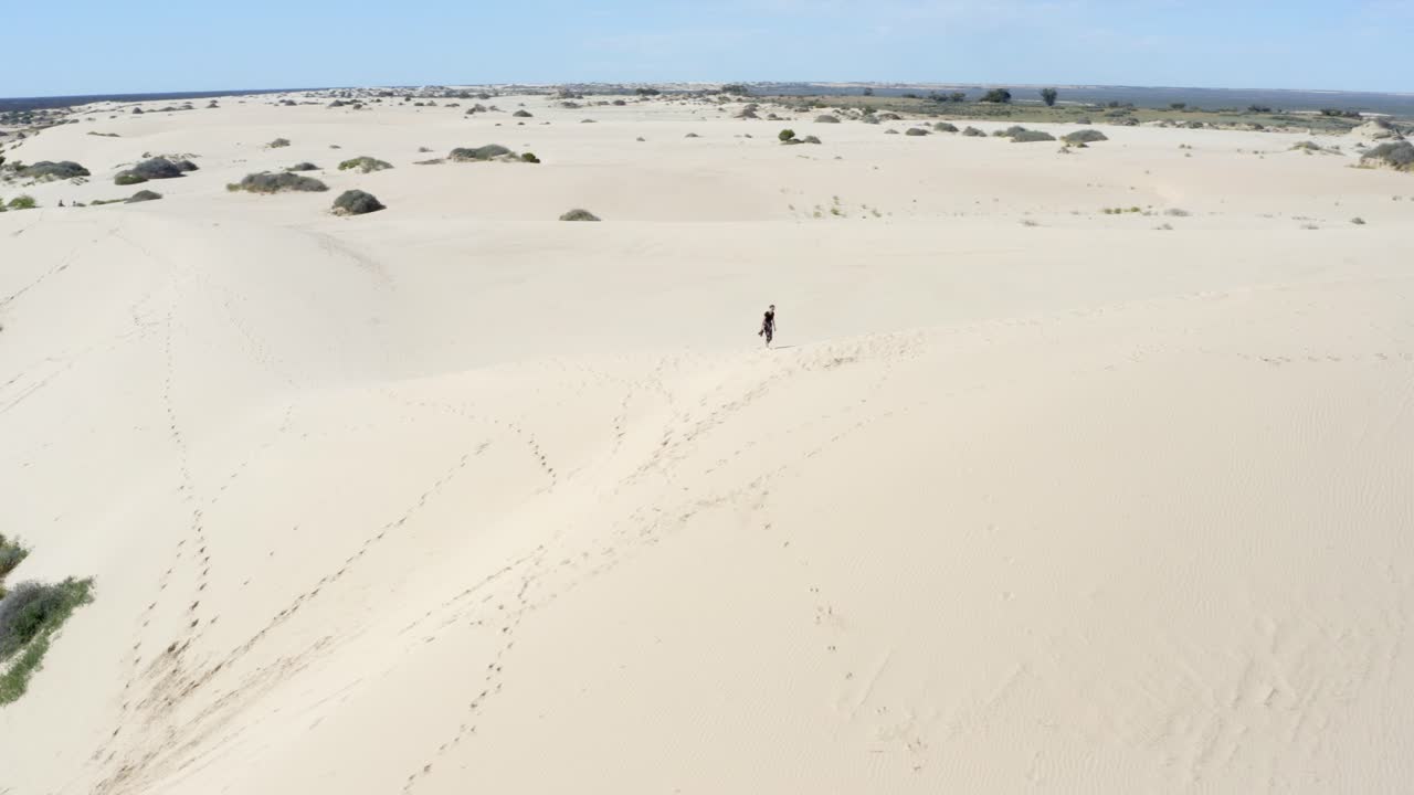 niña explorando enormes dunas de arena en un desierto australiano en un día caluroso y soleado, toma aérea