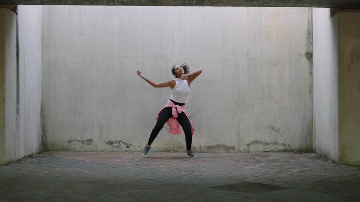 dancing woman young mixed race street dancer performing freestyle hip hop moves enjoying modern dance expression practicing in grungy warehouse